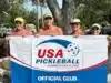Nude pickleball enthusiasts holding up a sign